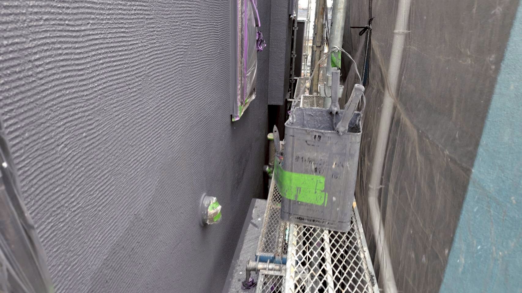 上塗り材で仕上げ中の吹き付け塗装外壁